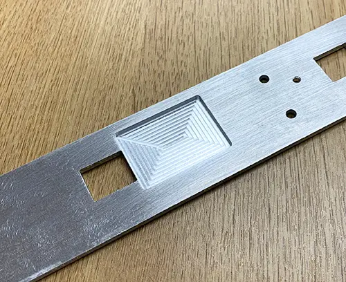 Recess milled into the rear face of a front panel for locating an electronic component.